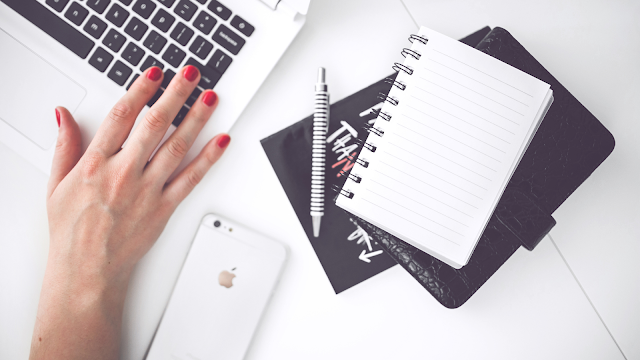 Ambiente de trabalho minimalista e organizado Secretária branca com portátil, caderno e telemóvel, representando organização digital e produtividade