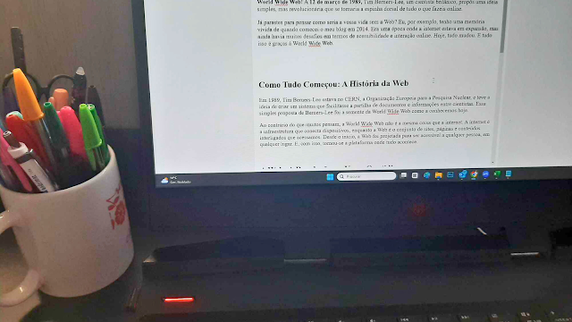 Imagem de um laptop com a tela exibindo um post do blog sobre o aniversário da World Wide Web, com conteúdo sobre a evolução da Web e seu impacto na vida digital.