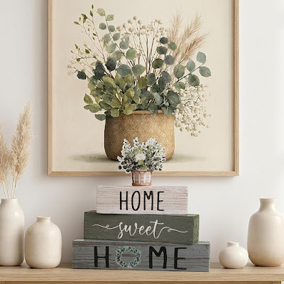 Decoração primaveril com apontamentos naturais e mensagem home Composição decorativa primaveril com jarras em cerâmica clara, quadro botânico, elementos em fibras naturais e blocos decorativos com a mensagem “Home Sweet Home”, criando um ambiente acolhedor e harmonioso.