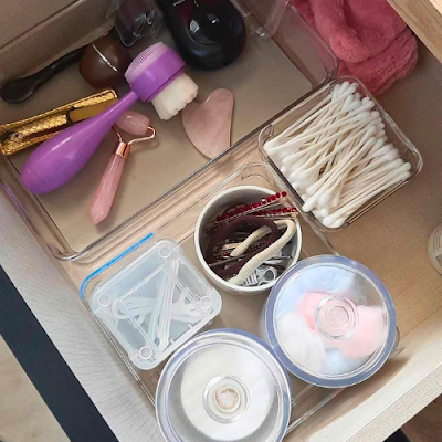 Organização da Gaveta de Beleza Gaveta com acessórios e produtos de beleza organizados em caixas transparentes: discos de algodão, cotonetes, ganchos, esponjas e ferramentas de skincare.