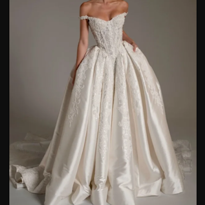 Vestido de noiva clássico com decote ombro a ombro Vestido de noiva clássico em tom marfim, com corpete rendado, decote ombro a ombro e saia volumosa em tecido acetinado