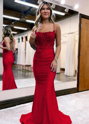 Red Mermaid Sequin Dress Elegance A young woman in a red mermaid sequin prom dress posing in a boutique setting with mirrors and dresses in the background.