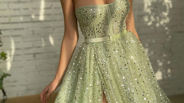 Vestido de festa curto com lantejoulas verde-claro, sem alças e com cinto, ideal para eventos formais ou ocasiões especiais.