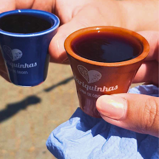 Licor de Óbidos na Feira Medieval de Santa Maria da Feira 2024 Duas mãos seguram copos de chocolate com licor de Óbidos durante a Feira Medieval de Santa Maria da Feira 2024.