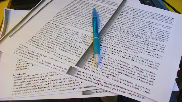 Folhas organizadas sobre uma mesa com canetas coloridas ao lado, representando um ambiente de trabalho ou estudo focado e produtivo.