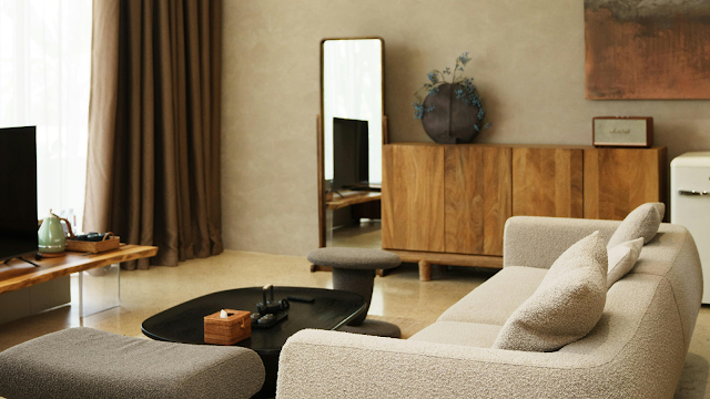 Sala com decoração primaveril em tons neutros e naturais Sala de estar com decoração primaveril, sofá em tons claros, móveis de madeira natural, mesa de centro preta e detalhes minimalistas que criam um ambiente luminoso, calmo e acolhedor.