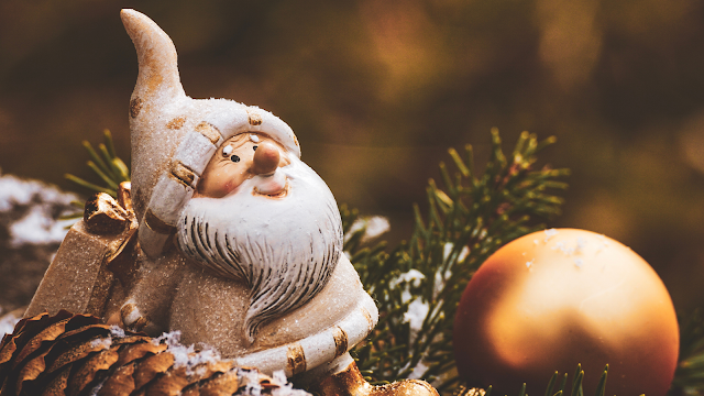 Raptaram o Pai Natal: e se a magia do Natal tivesse mesmo desaparecido? Estatueta do Pai Natal entre pinhas e ramos de pinheiro, simbolizando o espírito natalício e a perda da magia do Natal.